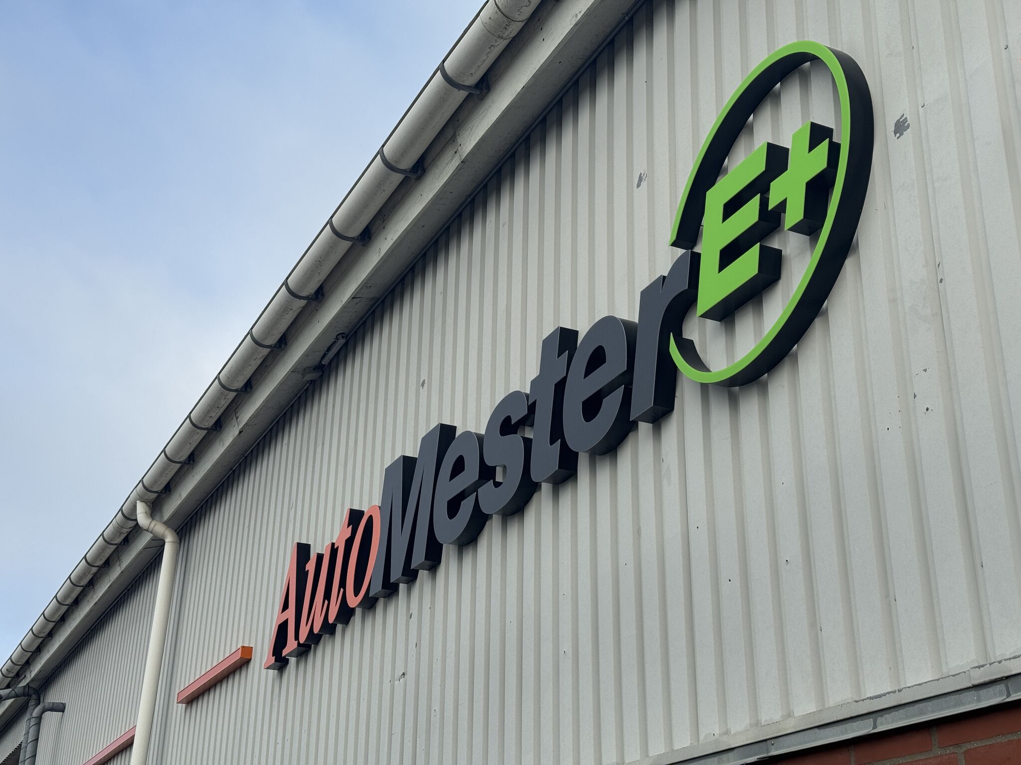 AutoMester E+ skilt på bygning