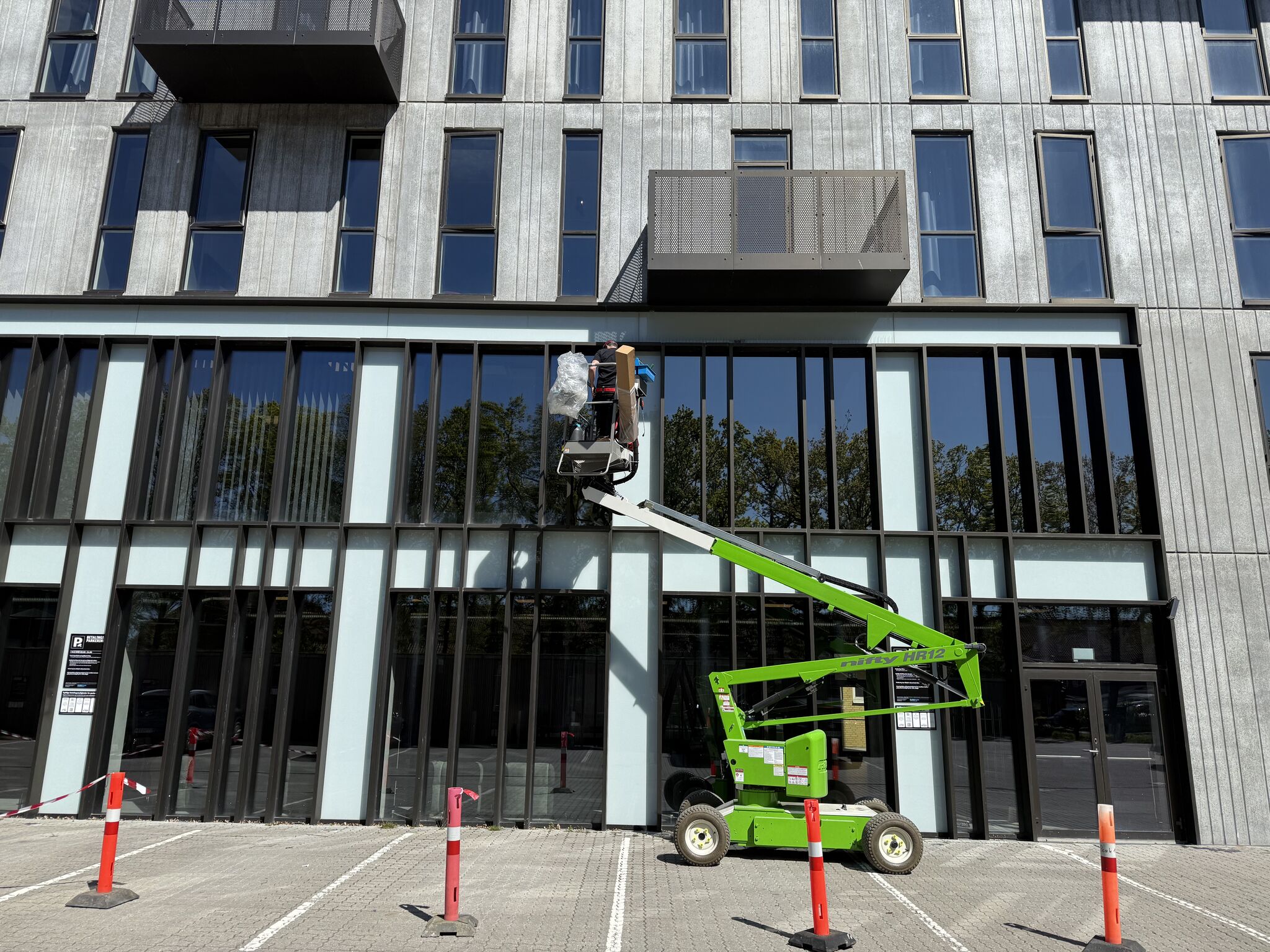 Mand arbejder på bygning med lift