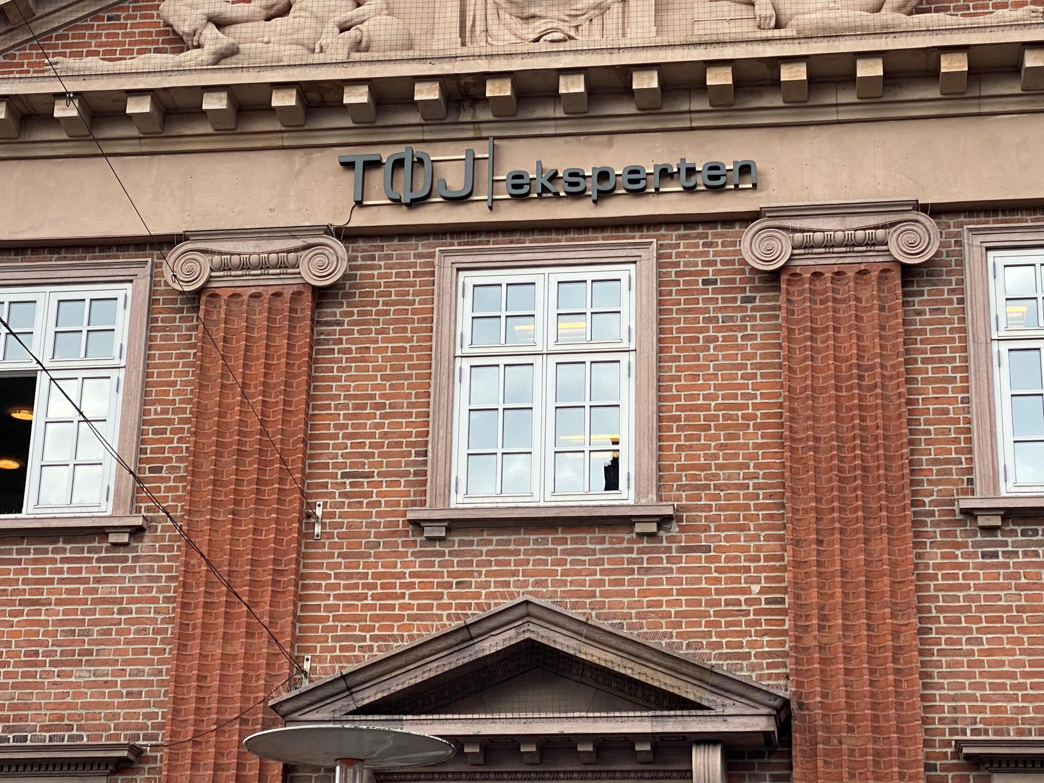 Butiksskilt på murstensbygning