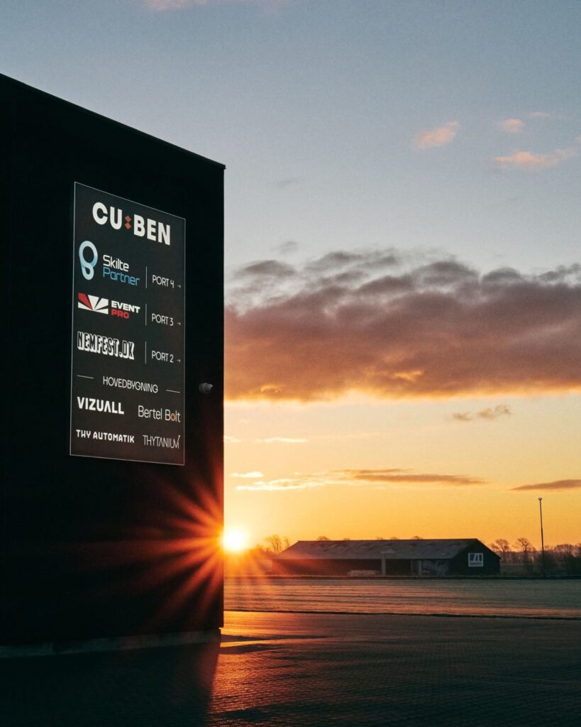 Solnedgang ved bygning med skilt