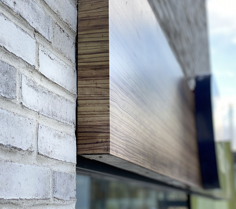 Træoverhæng ved murstensvæg til indgangsportaler