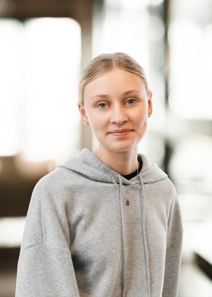 Ung person i grå hættetrøje.