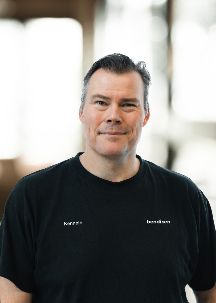 Mand i sort t-shirt, uskarp baggrund.