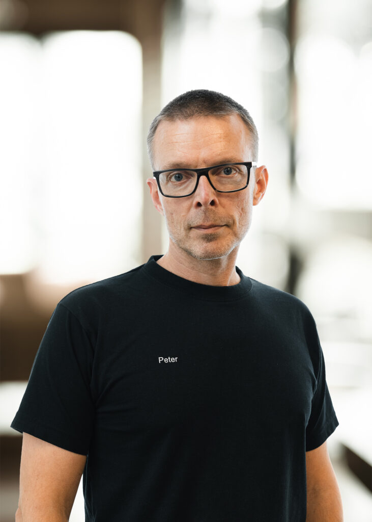 Mand i sort t-shirt, indendørs.